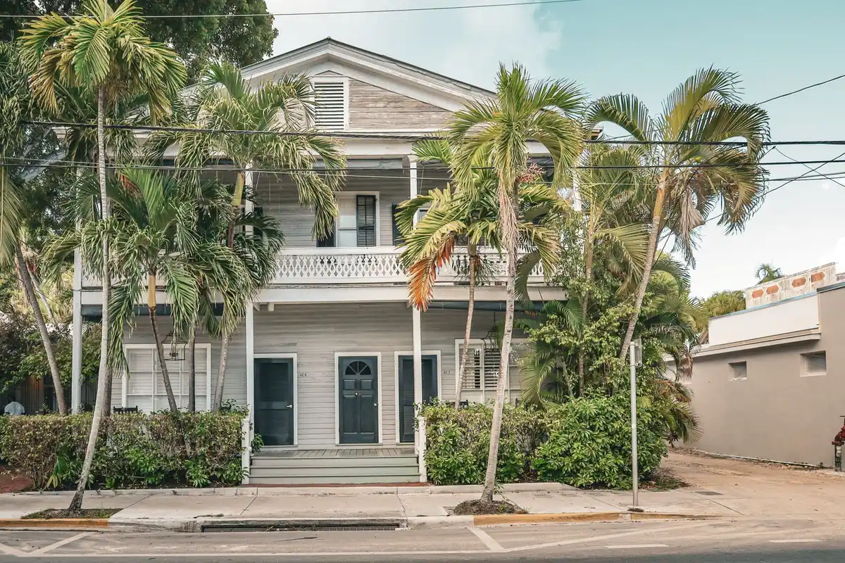 Coastal Florida home with white porches and palm trees