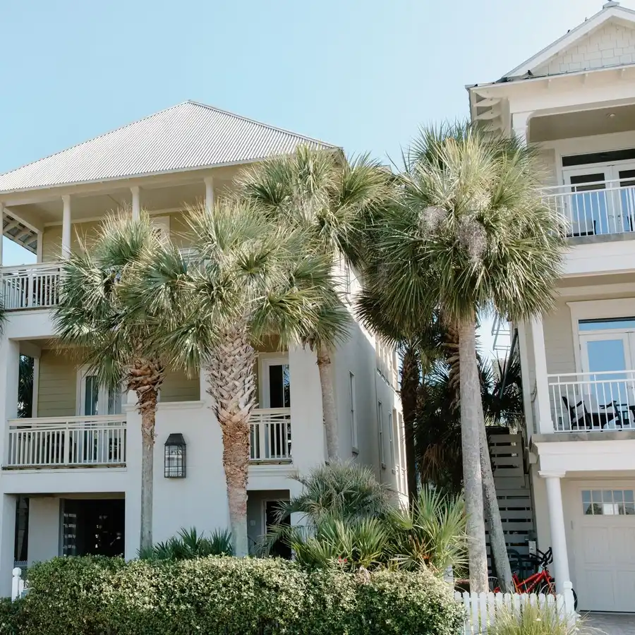 White two-story Florida beach house with palm trees