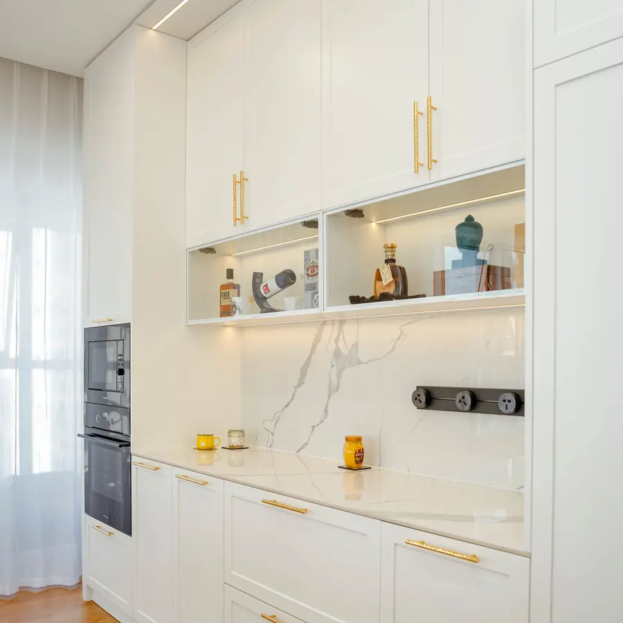 White built-in cabinets with open shelving and gold hardware