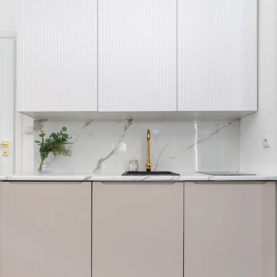 Kitchen with white flat-panel cabinets and a marble-look backsplash