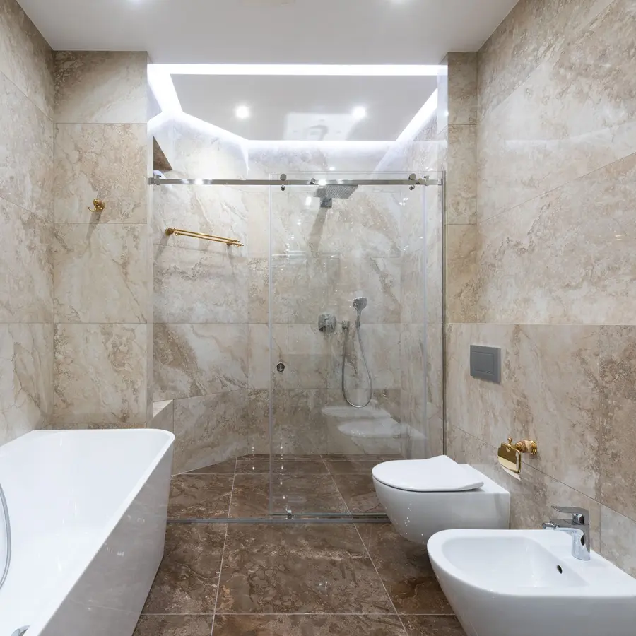 Remodeled bathroom with a freestanding tub, walk-in shower and marble tile